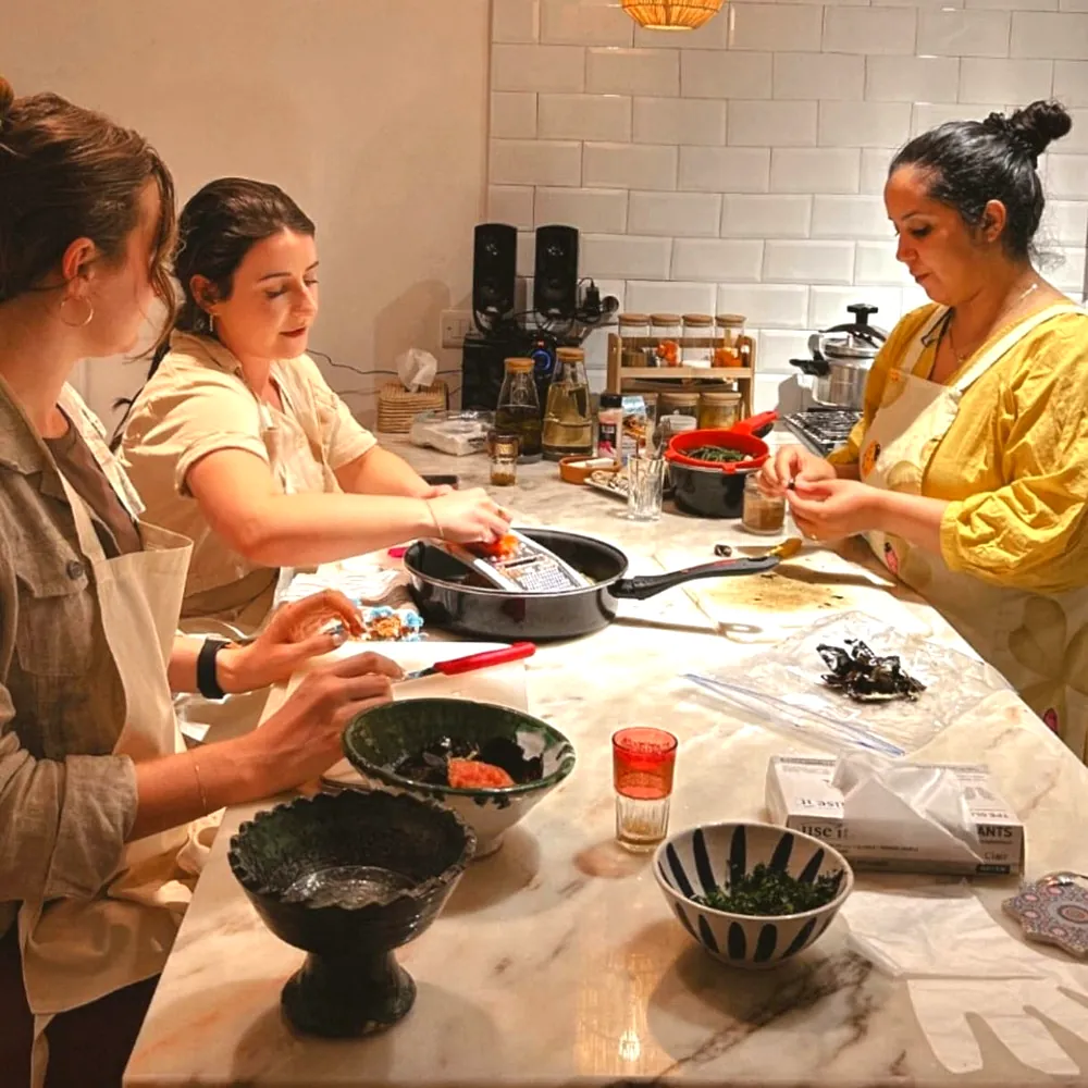 Guests cooking with their host at the kitchen counter during a private class